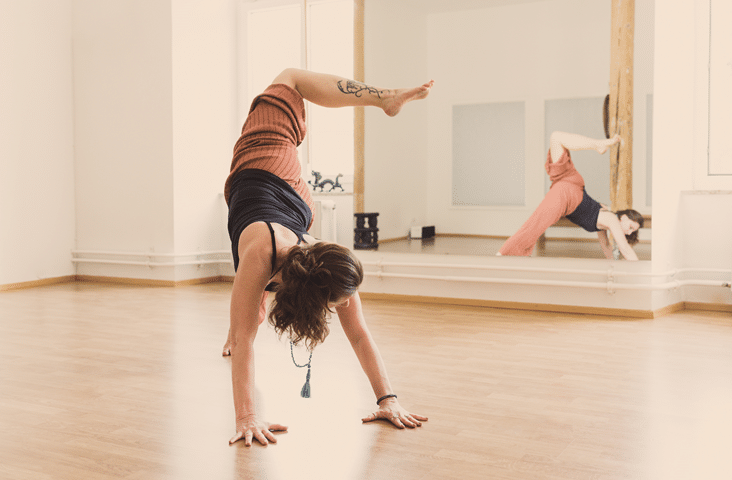 Claudia Galos, Yoga-Trainerin, in einer Yoga-Pose vor dem Spiegel