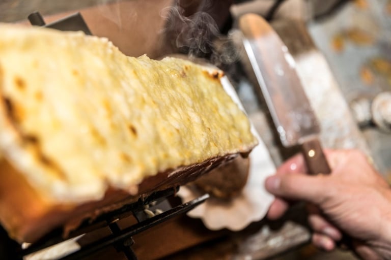 Großer Laib Raclette-Käse, der gleich abgeschabt wird